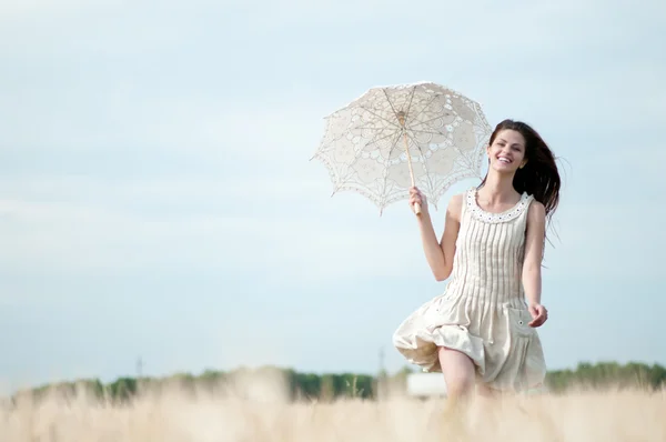Traurige Frau mit Regenschirm läuft in Feld — Stockfoto