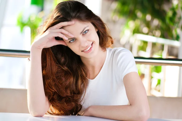 Een jonge vrouw in een café zitten — Stockfoto