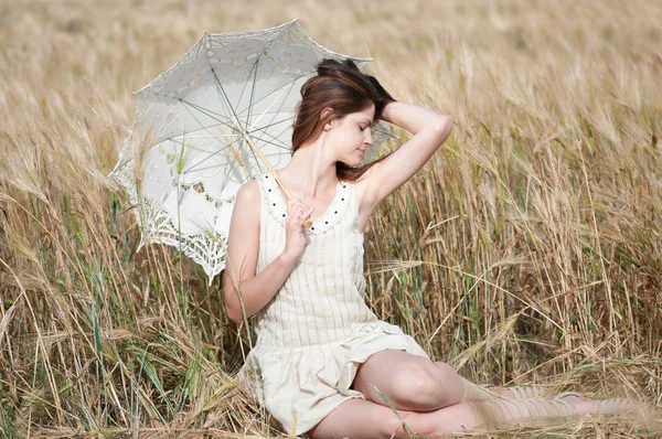 Samotna kobieta siedzi w polu pszenicy — Zdjęcie stockowe
