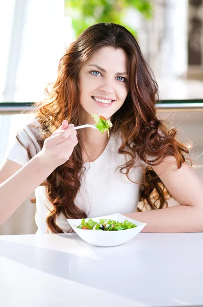 Une jeune femme dans un café avec un café avec salade — Photo