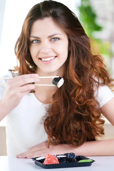 Молодая женщина сидит в кафе с суши — стоковое фото