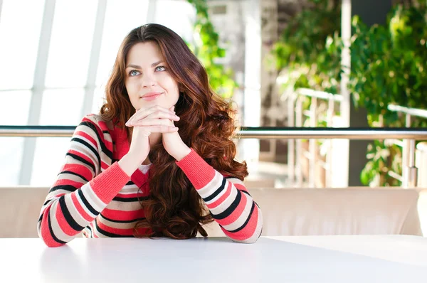 Een jonge vrouw in een café zitten — Stockfoto