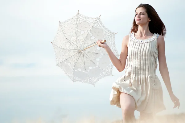 Traurige Frau mit Regenschirm läuft in Feld — Stockfoto