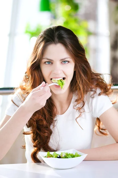 Une jeune femme dans un café avec un café avec salade — Photo
