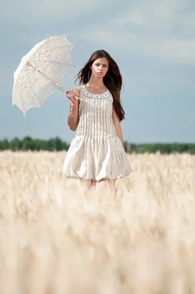 Eenzame vrouw lopen in een tarweveld. getimede. — Stockfoto