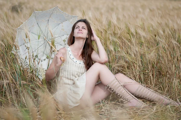 Einsame Frau sitzt im Weizenfeld — Stockfoto