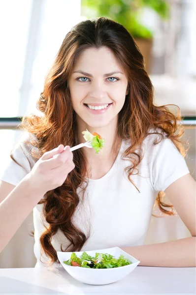 Uma jovem mulher em um café com um café com salada — Fotografia de Stock
