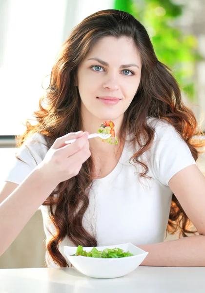 En ung kvinna i ett kafé med en kaffe med sallad — Stockfoto