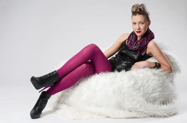 Schöne junge Rock-Mädchen auf Fell-Sofa — Stockfoto