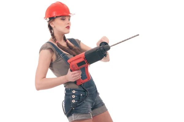 Young playful woman in jeans coverall holding perforator drill — Stock Photo, Image
