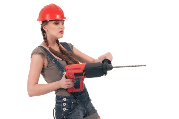 Young playful woman in jeans coverall holding perforator drill — Stock Photo, Image