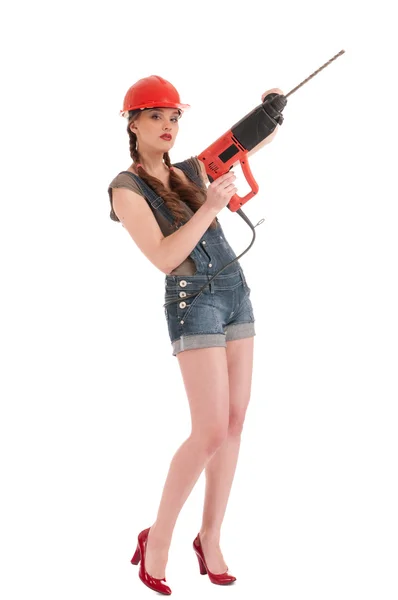 Молодая игривая женщина в джинсах держит перфоратор дрель — стоковое фото