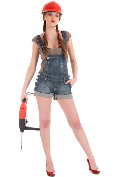 Молода грайлива жінка в джинсах обкладинка тримає дриль перфоратора — стокове фото