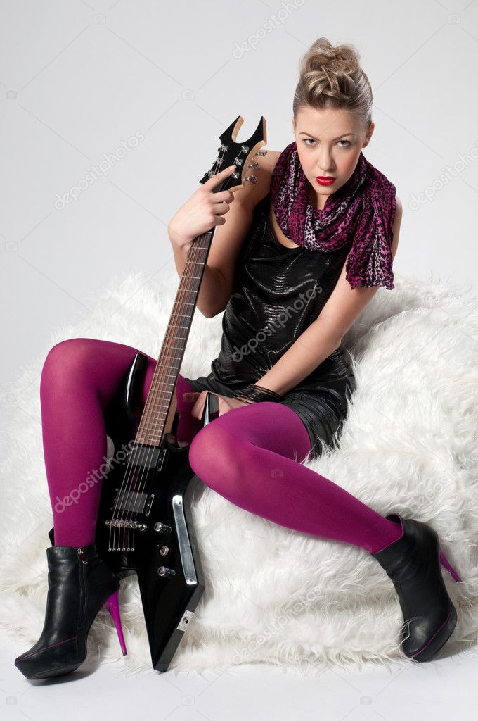 Beautiful young rock girl with black guitar