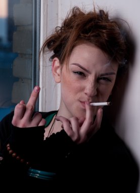 güzel bir genç kadın akşam pencereye Sigara.