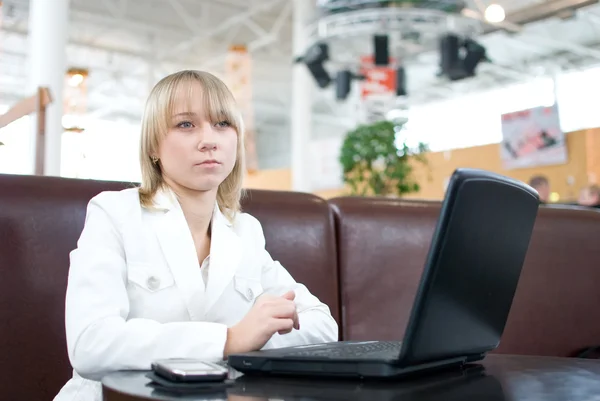 Jeune femme d'affaires avec ordinateur portable dans un café — Photo