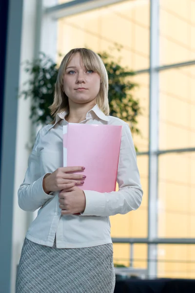 Young businesswoman with folder, paper in lobby — Stock Photo, Image