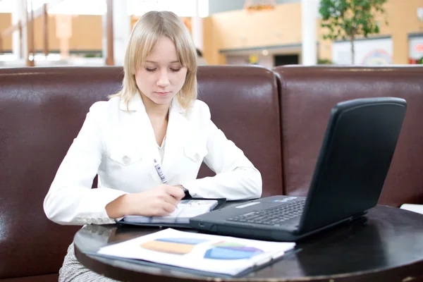 Jeune femme d'affaires avec ordinateur portable dans un café — Photo