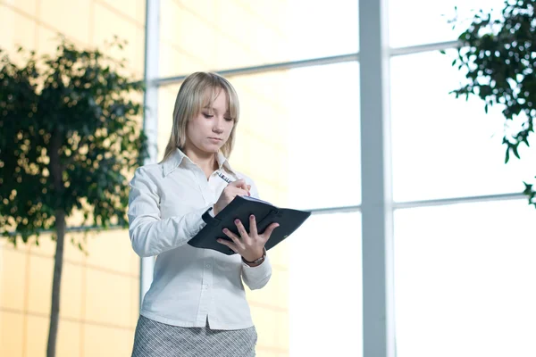 Young businesswoman with day planner in lobby — Stock Photo, Image