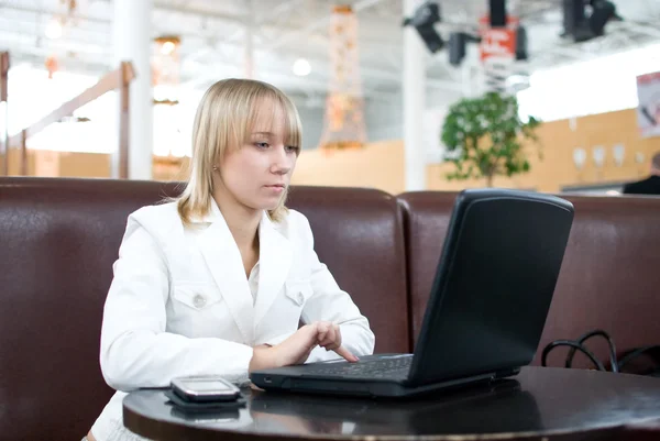 Jeune femme d'affaires avec ordinateur portable dans un café — Photo