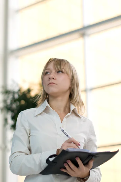 Jonge zakenvrouw met dag planner in lobby — Stockfoto