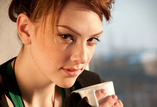 Belle jeune femme avec tasse de café sur la fenêtre — Photo