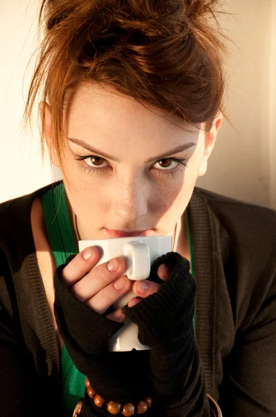 Vacker ung kvinna med kopp kaffe över fönster — Stockfoto