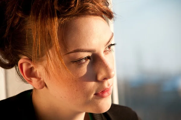 Vacker ung kvinna med kopp kaffe över fönster — Stockfoto