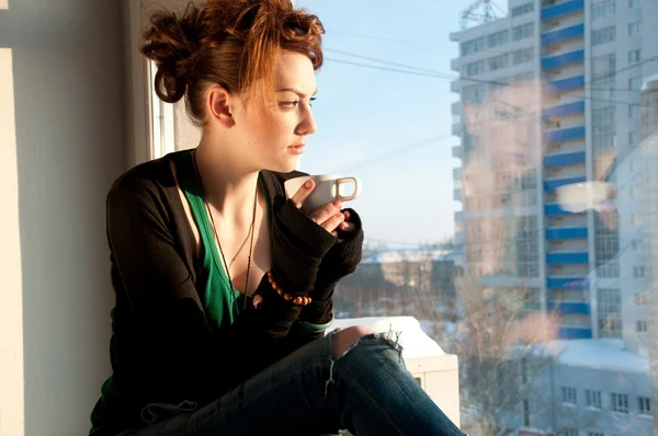 Bella giovane donna con tazza di caffè sopra la finestra — Foto Stock
