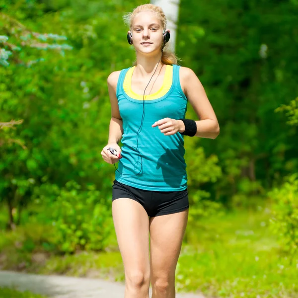 Beautiful young woman running on music — Stock Photo, Image
