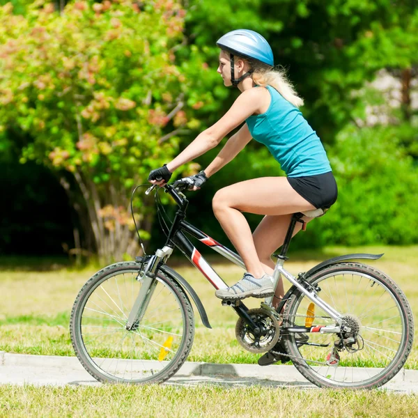 Молодая улыбающаяся женщина на велосипеде — стоковое фото