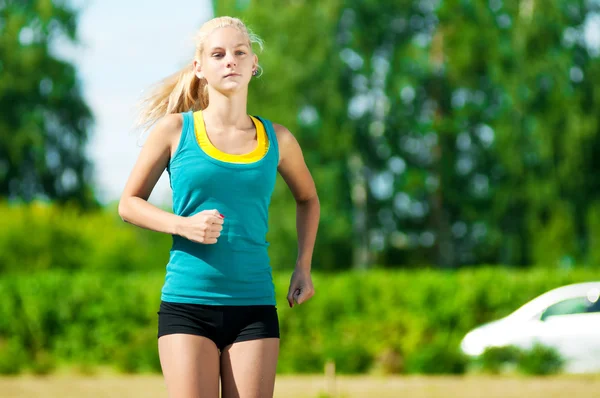 Young woman running in green park — Stock Photo, Image
