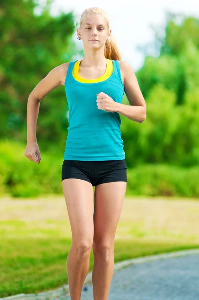 Young woman running in green park — Stock Photo, Image