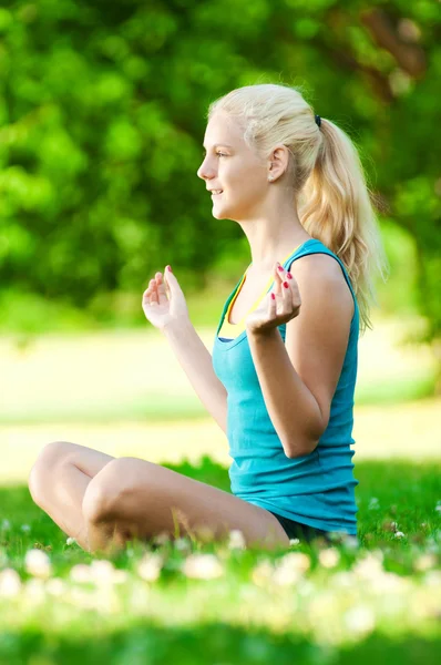 Yoga yapan genç bir kadın. — Stok fotoğraf