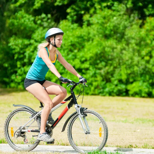 Unga leende kvinna på cykel — Stockfoto