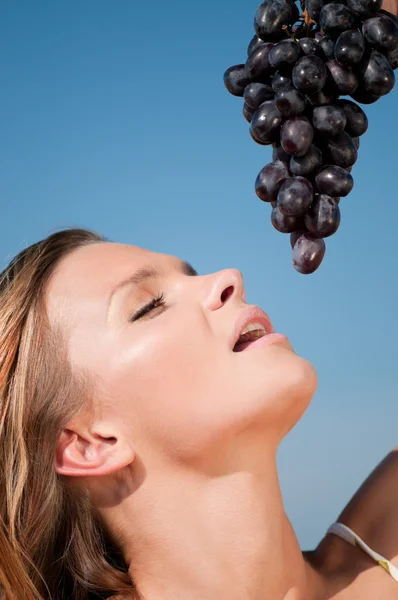 밀 필드 포도 먹는 여자입니다. 여름 피크닉. — 스톡 사진