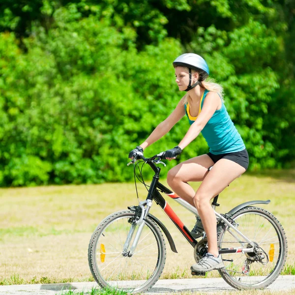 Young smiling woman on bike Royalty Free Stock Photos