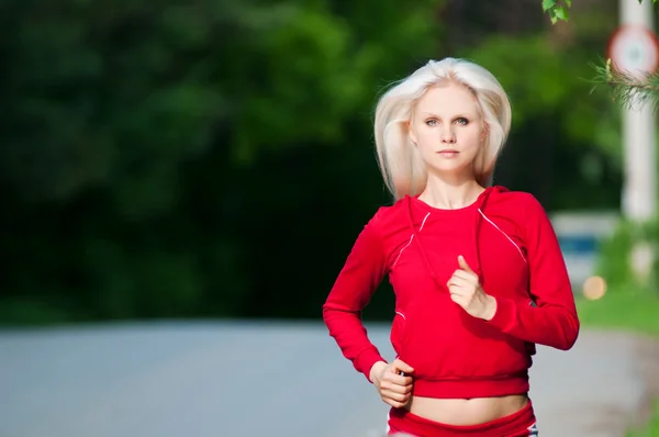Kaunis nainen juoksee puistossa — kuvapankkivalokuva