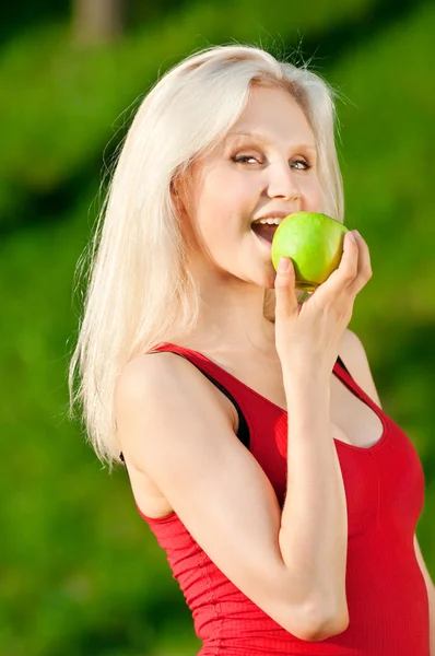 Kadın parkta yeşil elma — Stok fotoğraf