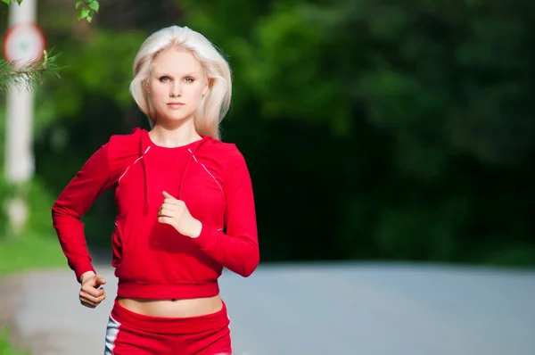 Vacker kvinna kör i park — Stockfoto