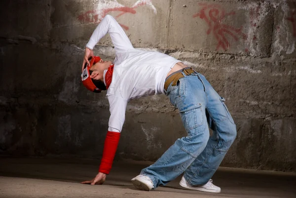 Hip-Hop-Junge tanzt modern über graue Backsteinmauer — Stockfoto