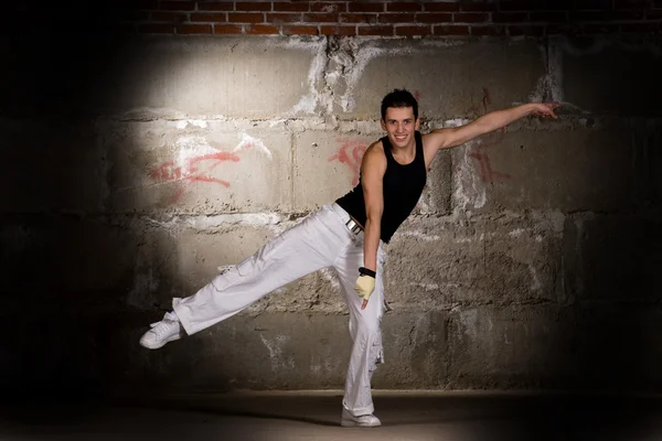 stock image Hip hop boy dancing in modern style over grey brick wall