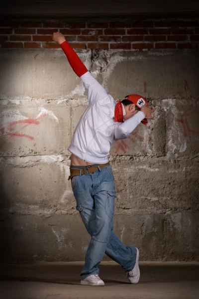 Hip hop chico bailando en estilo moderno sobre la pared de ladrillo gris —  Fotos de Stock
