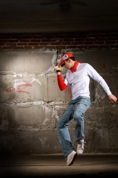 stock image Hip hop boy dancing in modern style over grey brick wall