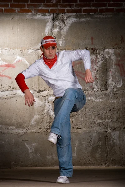 Hip hop chico bailando en estilo moderno sobre la pared de ladrillo gris — Foto de Stock