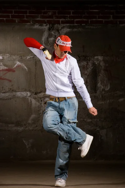 Hip hop chico bailando en estilo moderno sobre la pared de ladrillo gris — Foto de Stock