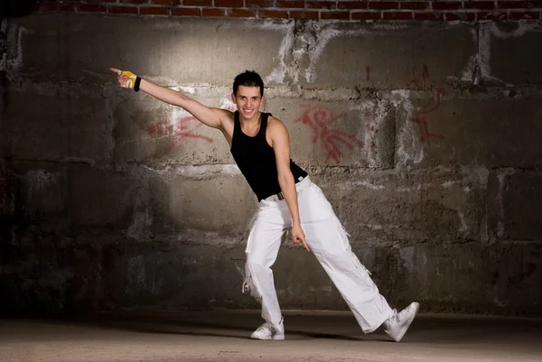 Hip hop boy tančí v moderním stylu nad šedou cihlová zeď — Stock fotografie