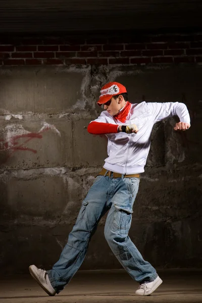 stock image Hip hop boy dancing in modern style over grey brick wall