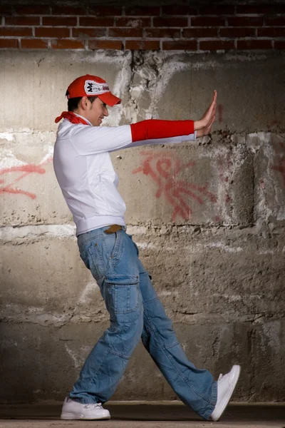 stock image Hip hop boy dancing in modern style over grey brick wall