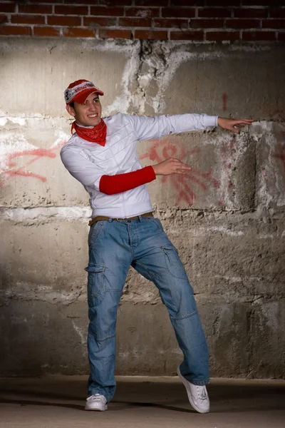 Hip hop chico bailando en estilo moderno sobre la pared de ladrillo gris — Foto de Stock